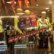 Vidriera de un comercio de Posadas con carteles de descuentos para clientes